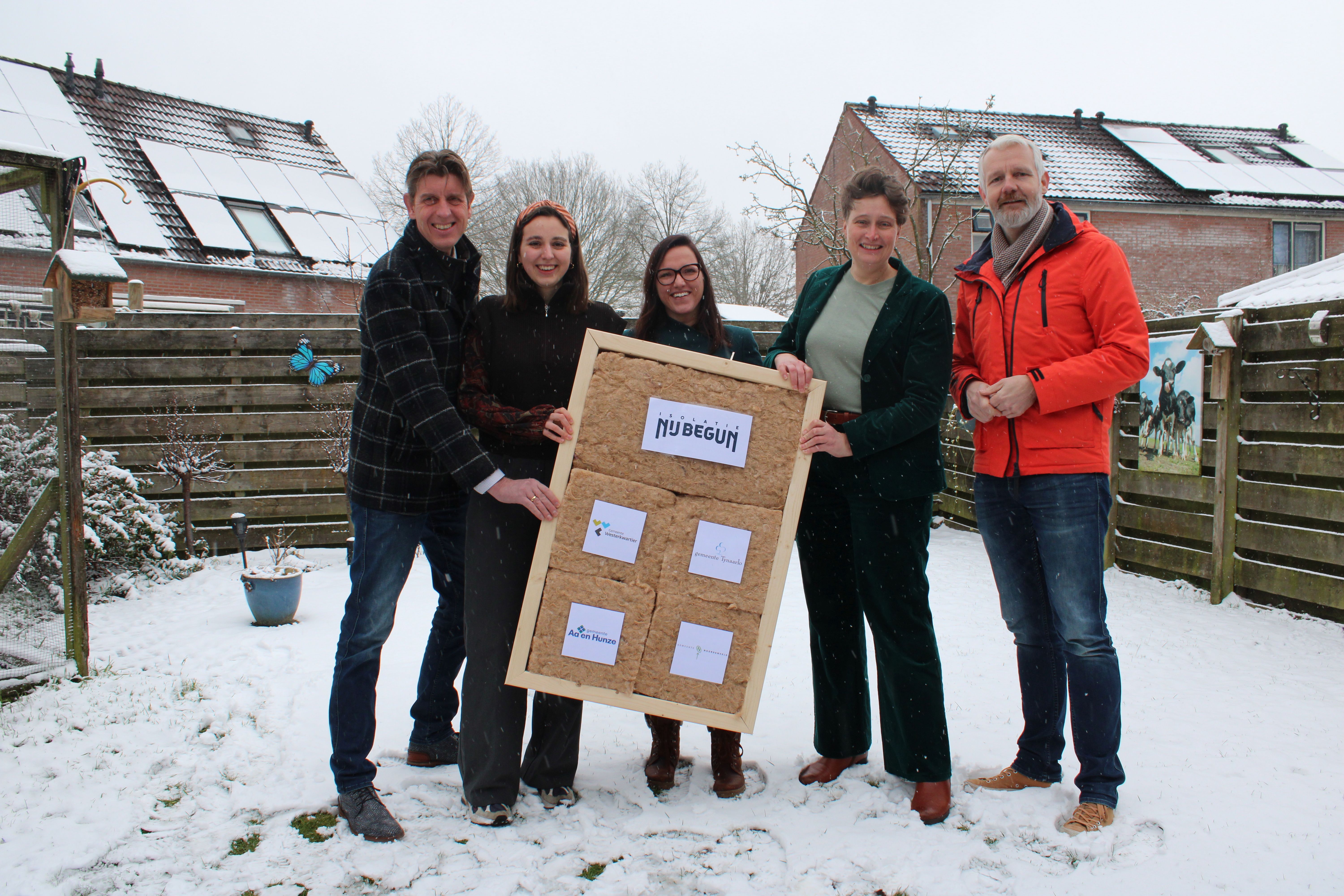 5 personen in de sneeuw die een bord met isolatiemateriaal vasthouden
