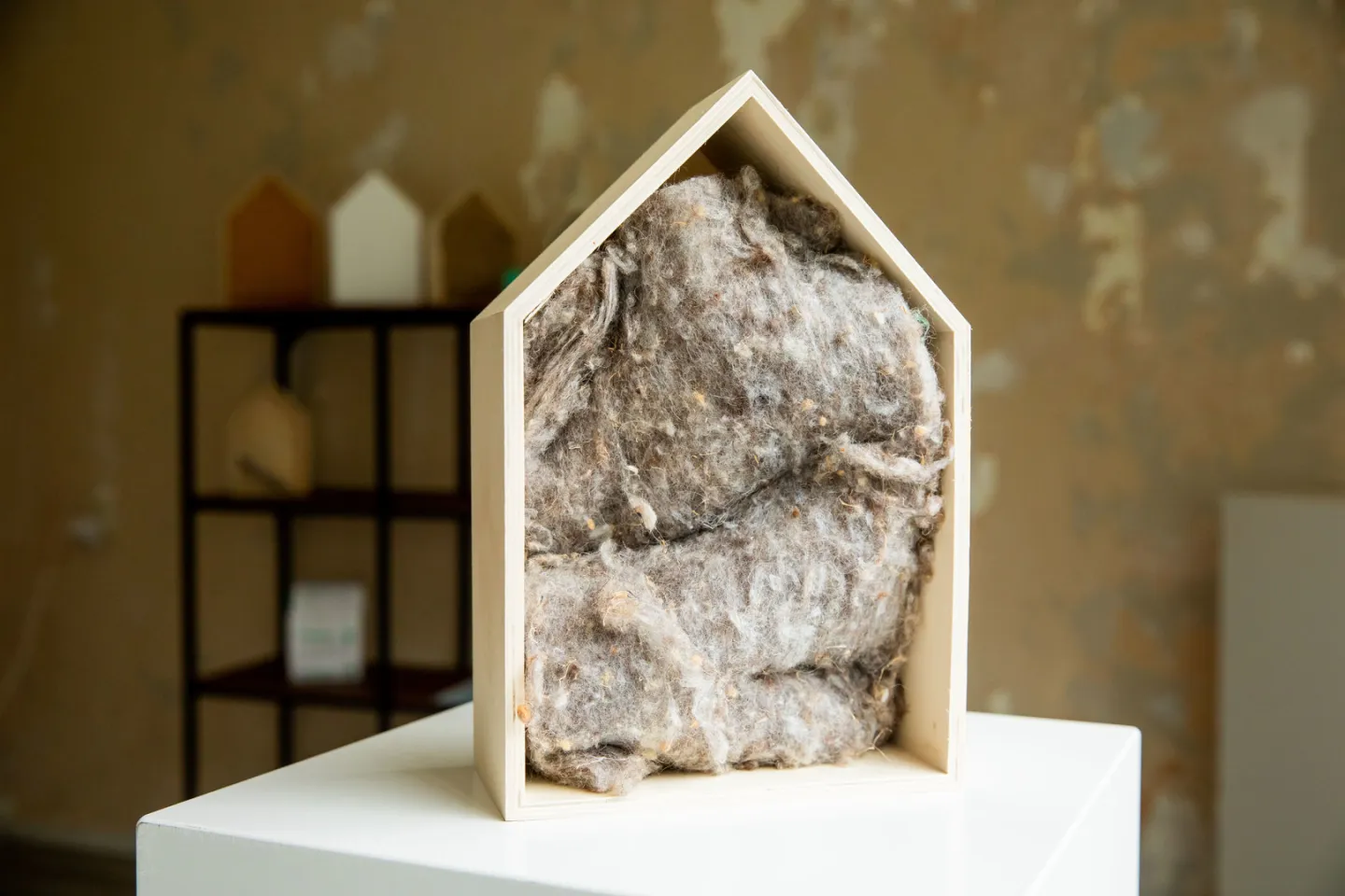 Houten frame in de vorm van huisje met puntdak, met daarin isolatiemateriaal